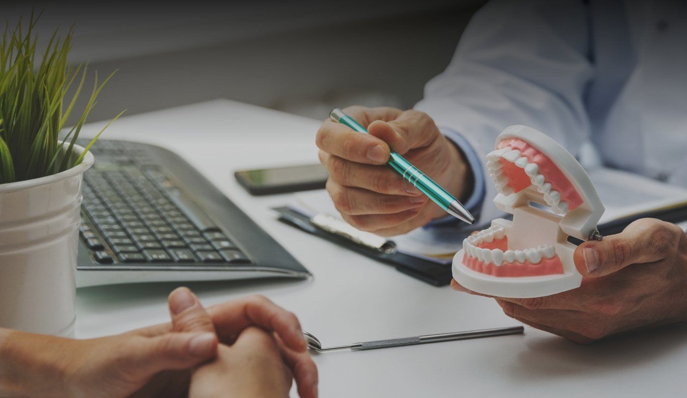 Dentist using smile model to explain the process for diagnosing T M J dysfunction