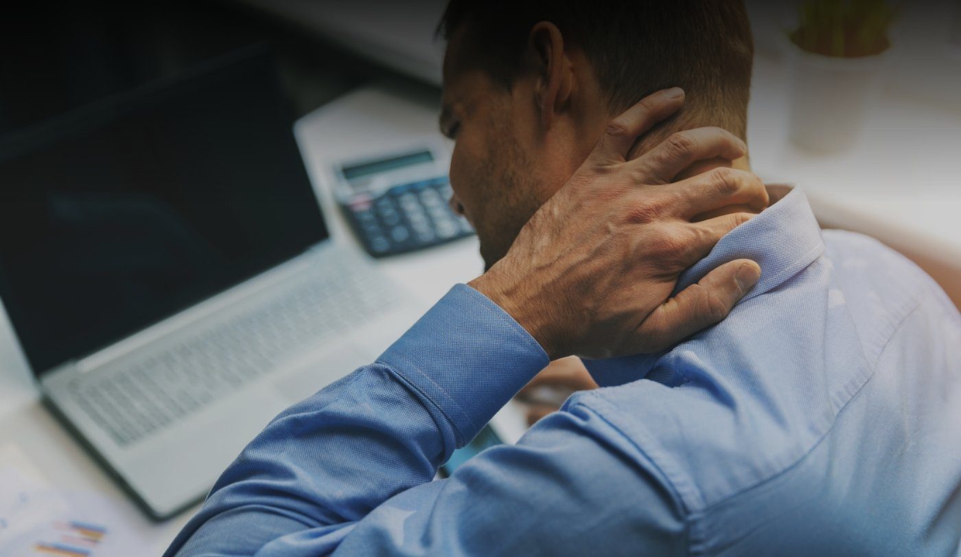 Man holding the back of his neck experiencing ear and neck pain