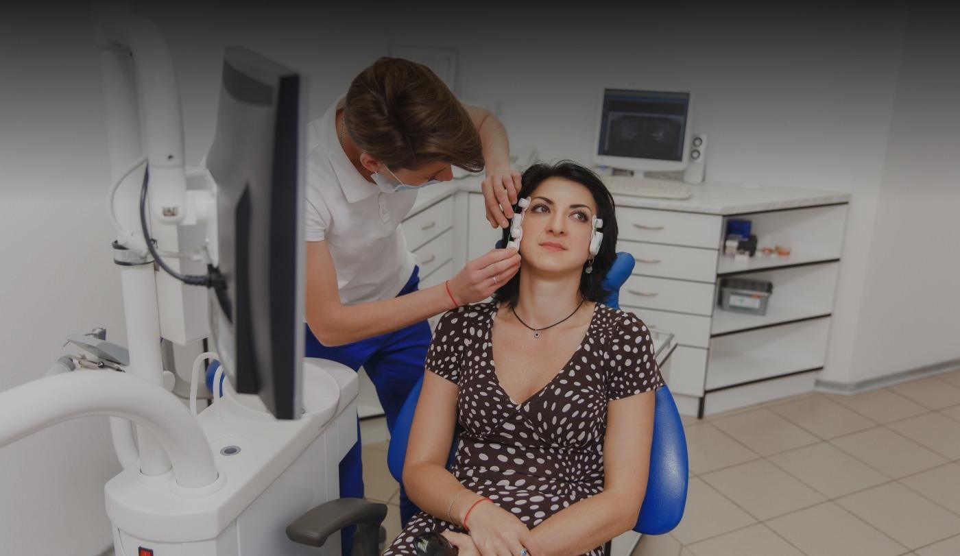 Dentist placing diagnostic device before providing neuromuscular dentistry