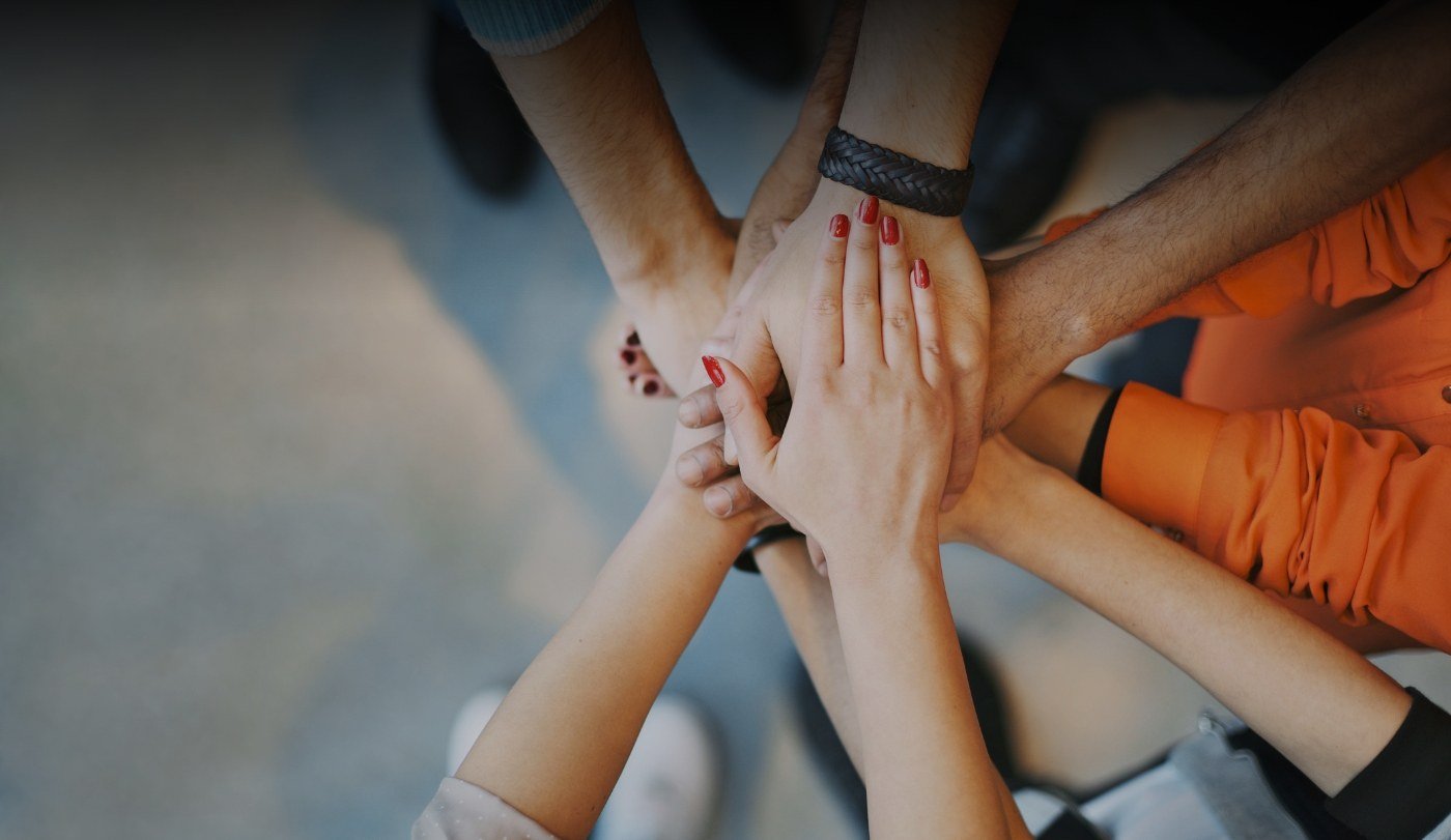 Group of people putting their hands together in a circle