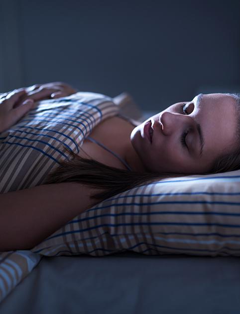 Woman lying in bed sleeping with central sleep apnea