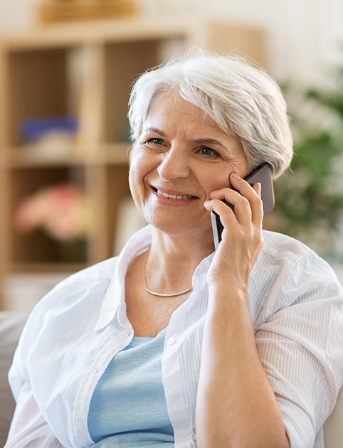 Senior woman on couch talking on phone