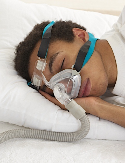 Man sleeping soundly using combined therapy for sleep apnea
