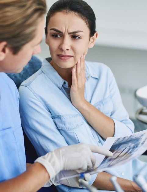 Woman discussing treatment for ear and neck pain with her dentist