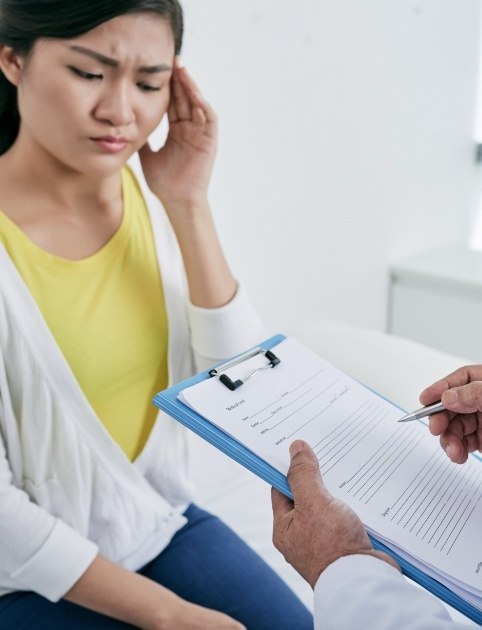 Woman talking to dentist about alleviating headaches and migraines