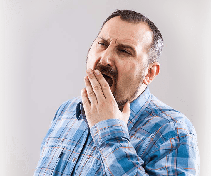 Tired yawning man in need of sleep apnea treatment