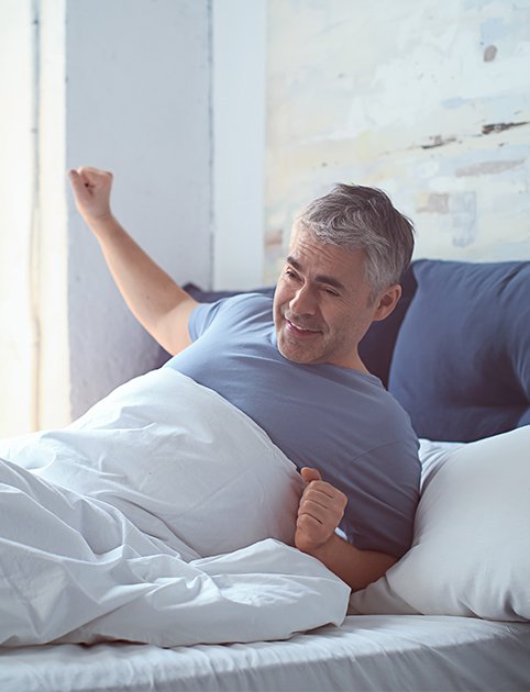 Man waking feeling rested thanks to Respire oral appliance therapy for sleep apnea