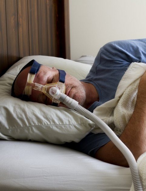 Man using CPAP system for sleep apnea treatment