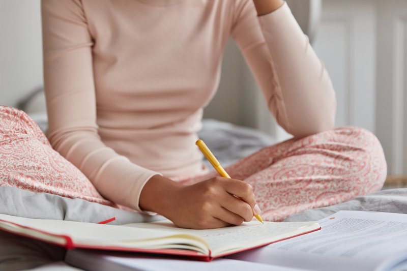 young woman writing in sleep diary