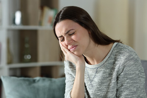 Woman on couch with a TMJ disorder