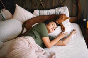 Sleeping woman and dog in bed