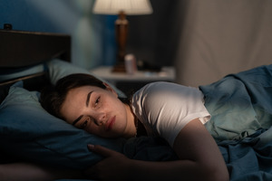 Woman lying awake in bed feeling anxious